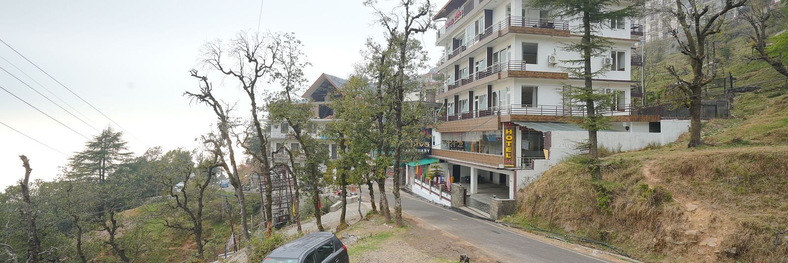 Image of the hotel from a side angle with trees in the background | DLS Hotel Shiva Sanctuary and Spa